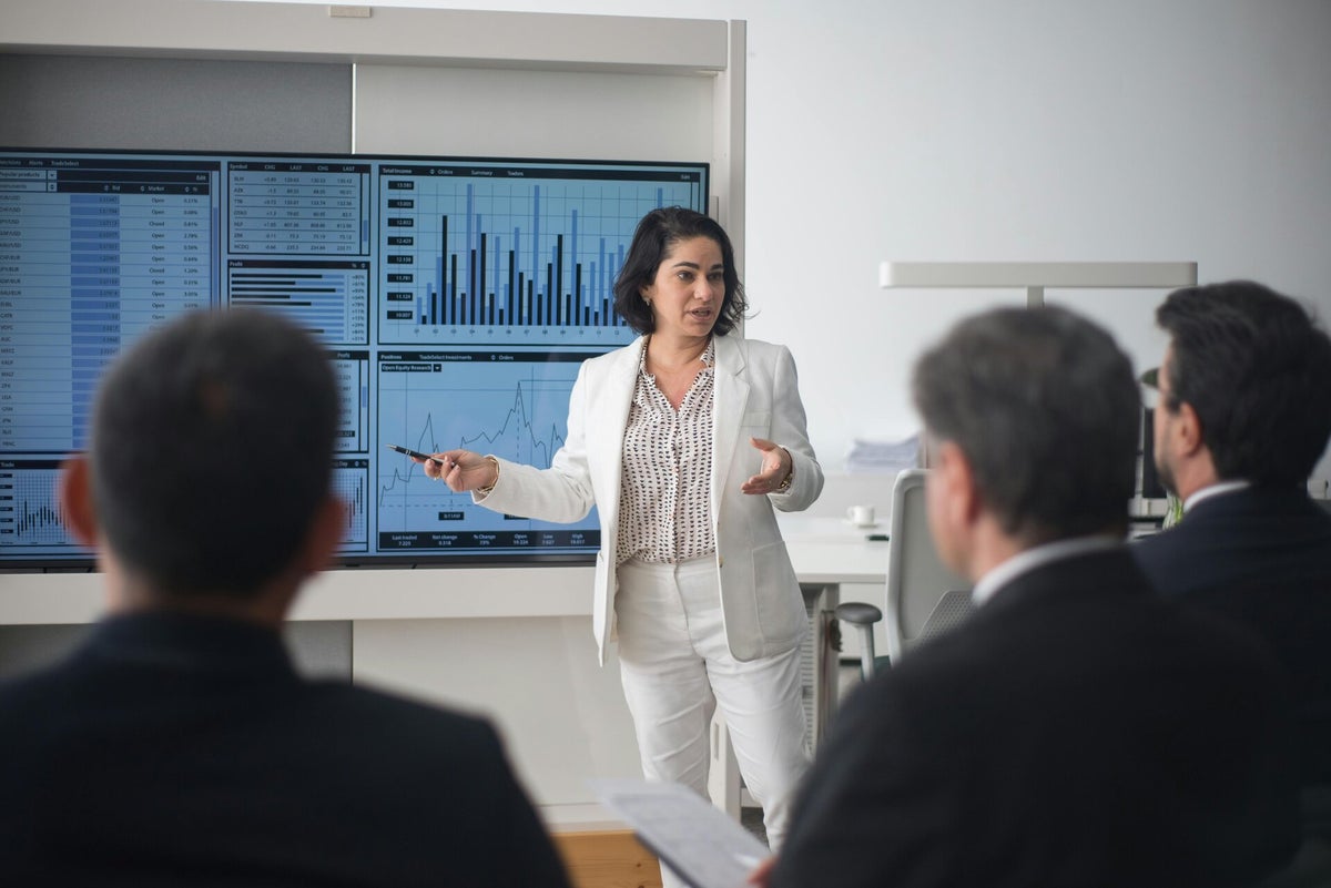 A finance professional presenting data to colleagues